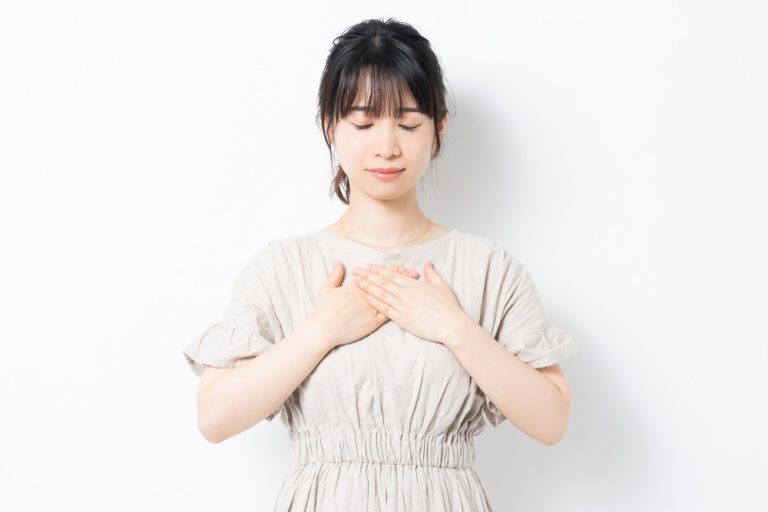 胸に手を当てる若い女性