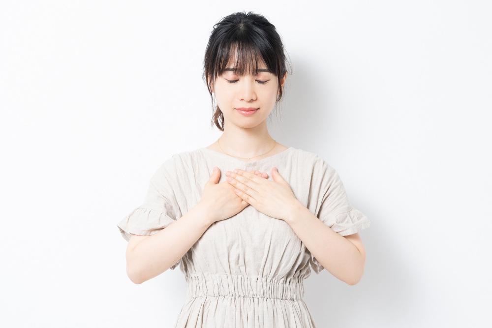 胸に手を当てる若い女性