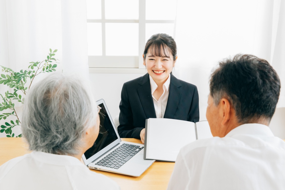 年配の夫婦に提案する女性
